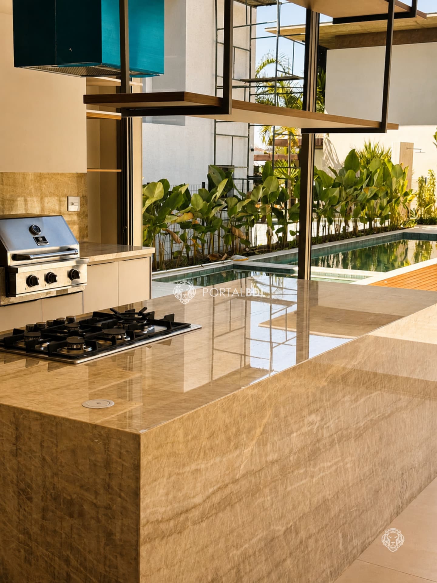 Ilha gourmet em quartzito com cooktop e churrasqueira voltada para a piscina